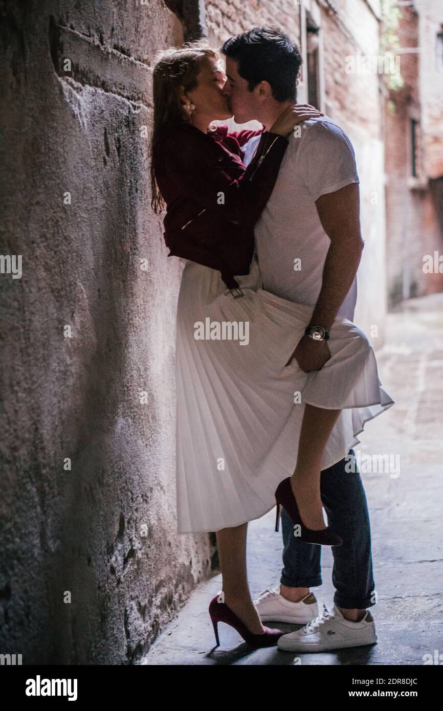 Young Couple Kissing Against Wall High Resolution Stock Photography and