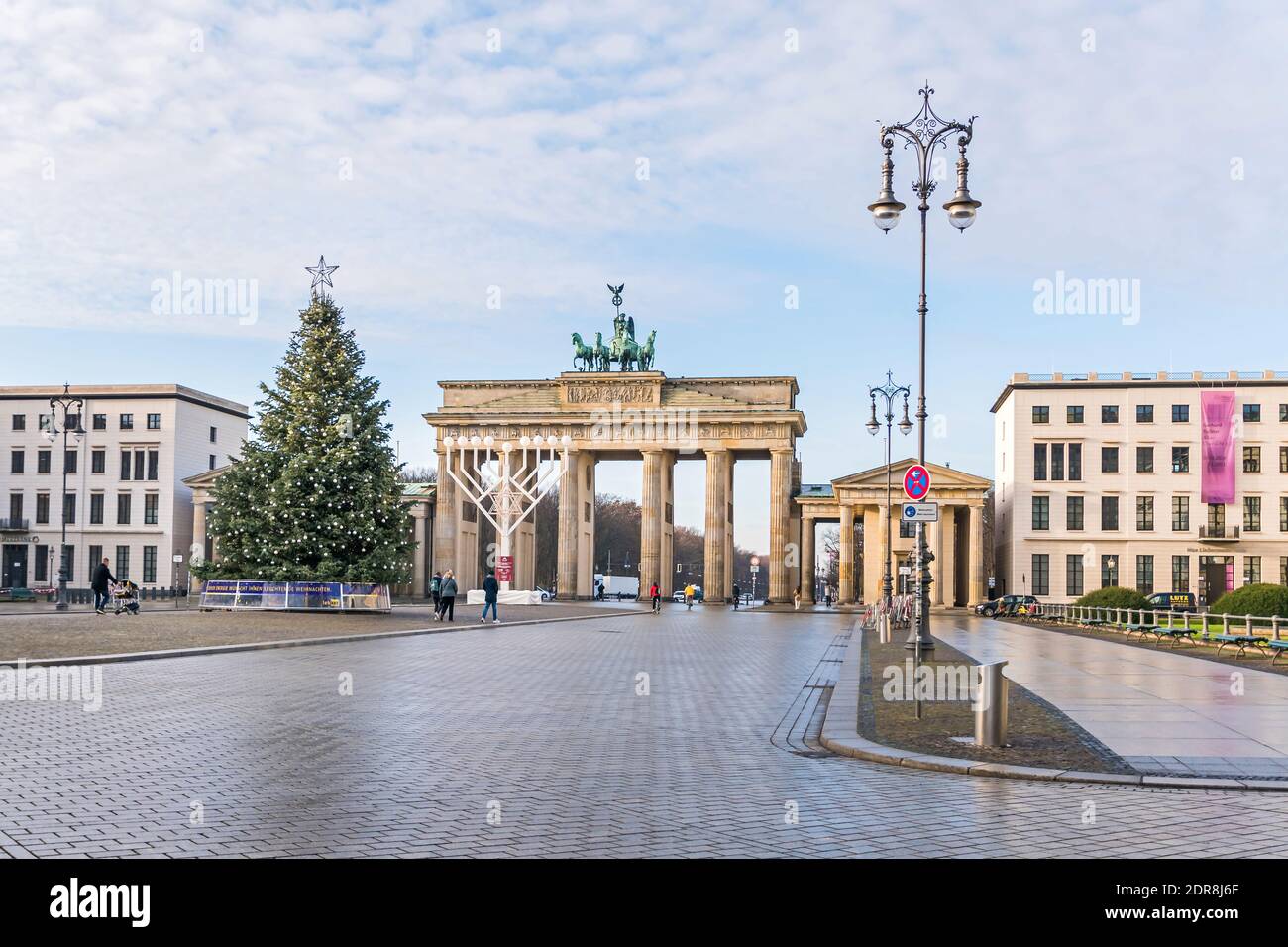 Berlin, Germany - December 18, 2020: Historic square Pariser Platz with the Brandenburg Gate, largest Hanukkah candlestick in Europe and a decorated C Stock Photo