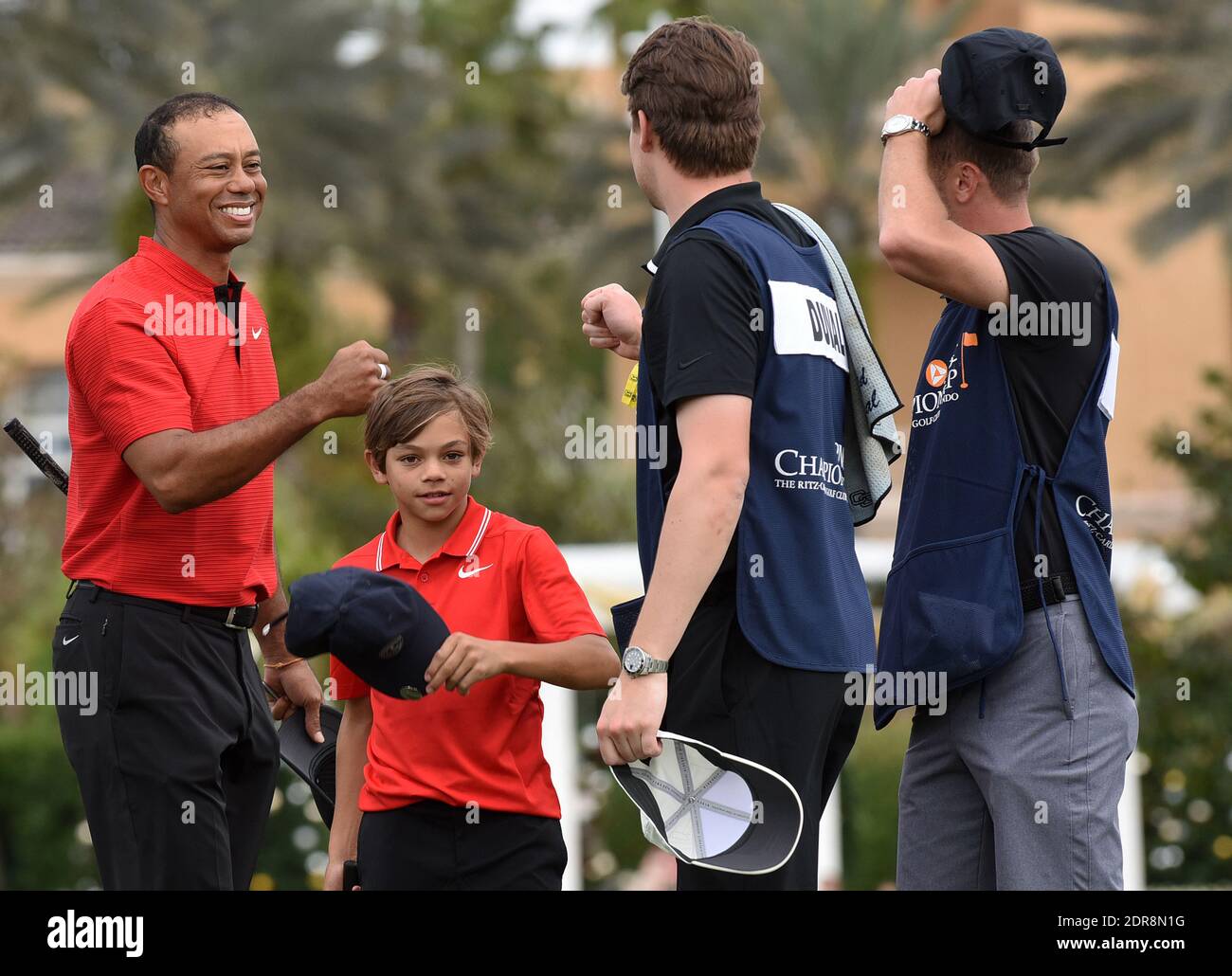 Tiger Woods and his son Charlie fist bump with the caddies after