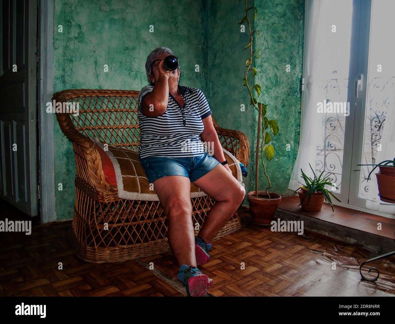 Woman Drinking Wine On Chair At Home Stock Photo