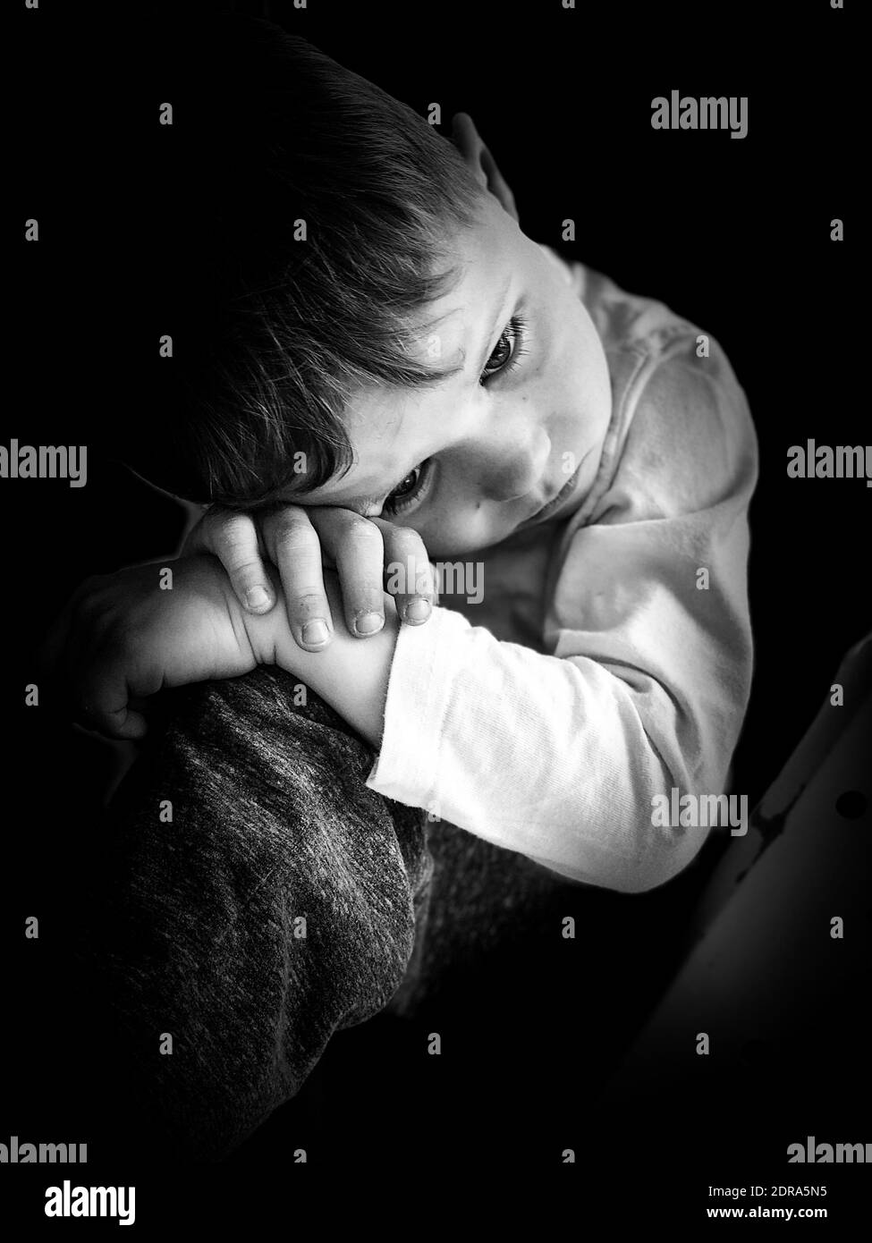 Close-up Of Sad Boy Looking Away While Relaxing Against Black Background  Stock Photo - Alamy
