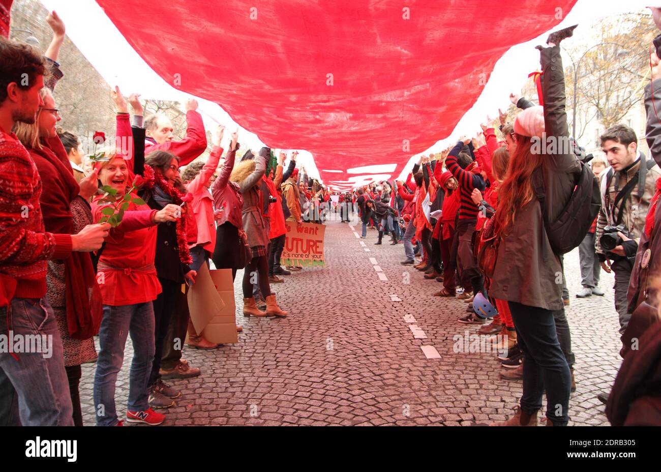 Activists form a giant red line during a demonstration near the Arc de Triomphe at the Avenue de la Grande armee boulevard in Paris, France, on December 12, 2015, as a proposed 195-nation accord to curb emissions of the heat-trapping gases that threaten to wreak havoc on Earth's climate system is to be presented at the United Nations conference on climate change COP21 in Le Bourget, on the outskirts of Paris. Photo by Somer/ABACAPRESS.COM Stock Photo