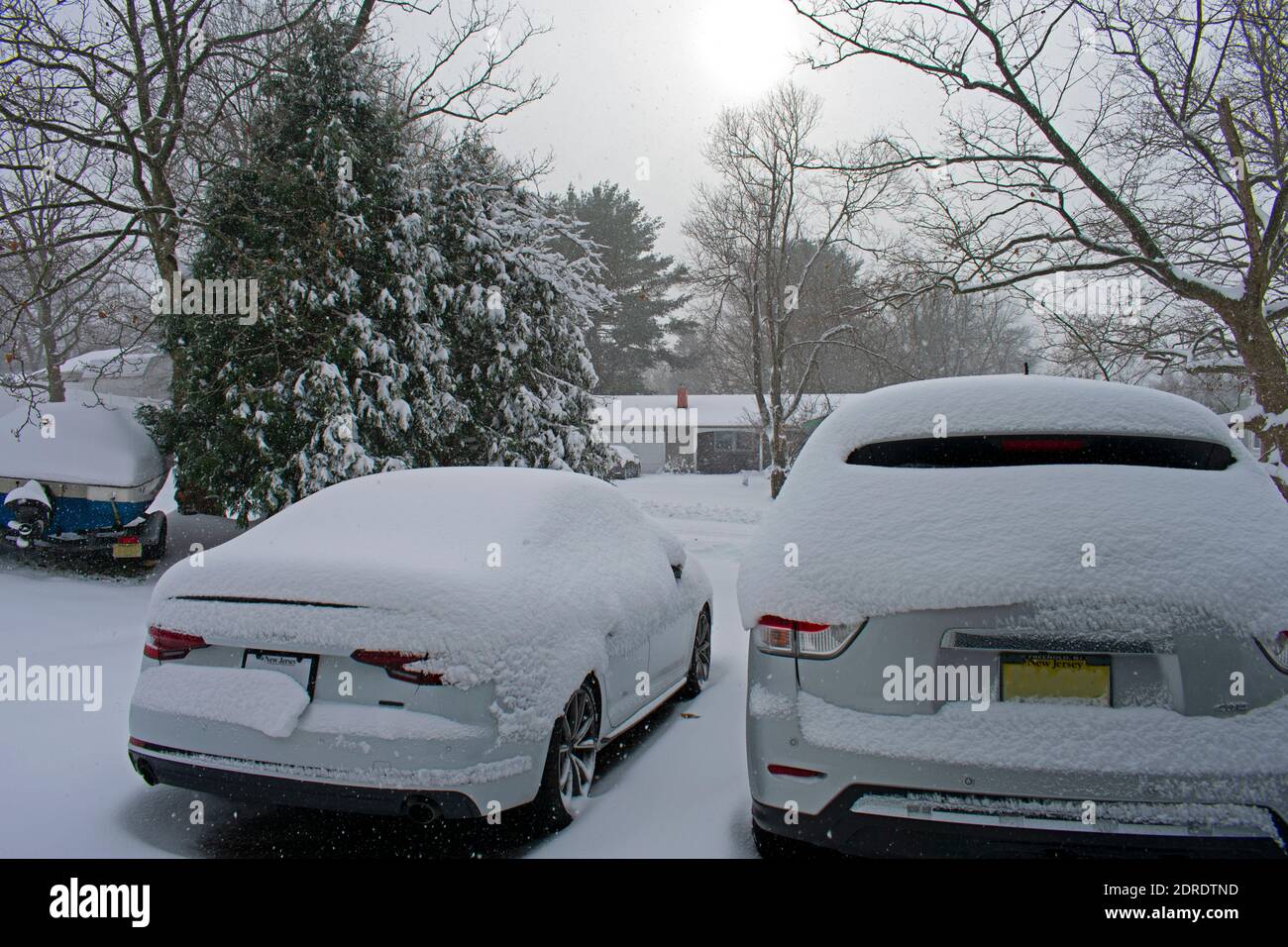 Looking at snow falling on street and cars from the safety of a residential garage in a suburban town -04 Stock Photo