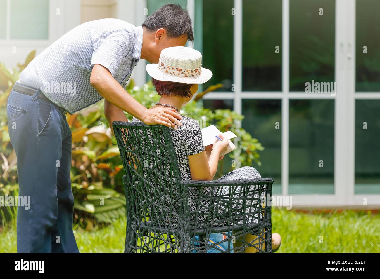 Asian middle aged couple sitting and relax in backyard Stock Photo - Alamy