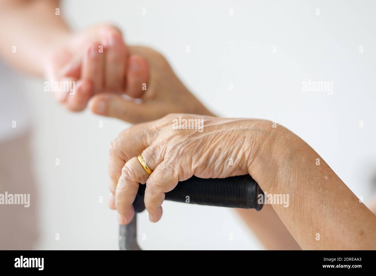 Elderly asian woman using a cane at home with caregiver take care Stock Photo