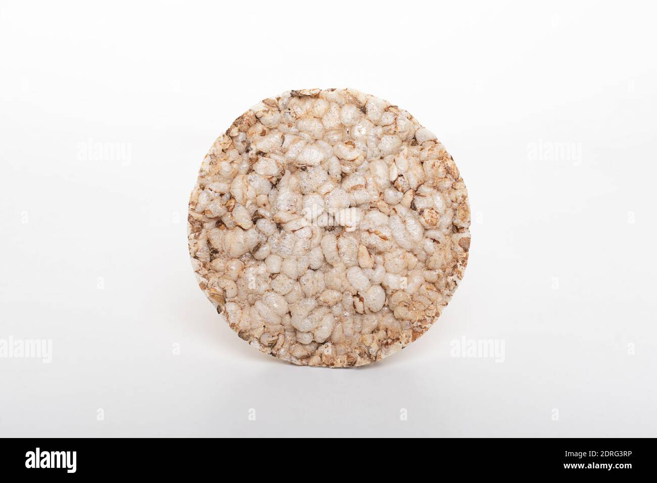 Round slice of airy crispy buckwheat rice bread loaf isolated on white background. Stock Photo