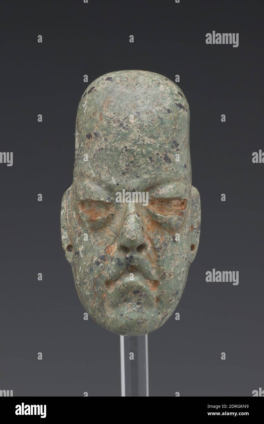 Head, originally from a Figure, reused as a Pendant, 900–400 B.C., Greenstone (probably jadeite) with pigment, 8 × 5 × 5 cm (3 1/8 × 1 15/16 × 1 15/16 in.), Long after the demise of the Olmecs, Mesoamerica’s earliest major civilization, which dominated the Gulf Coast of Mexico from ca. 1500 to 400 B.C., their art objects were prized as relics of fabled antiquity by the civilizations that later rose to power in the region, such as the Maya and the Aztecs. This head originally belonged to an entire figure, but the body was apparently decapitated at some point Stock Photo