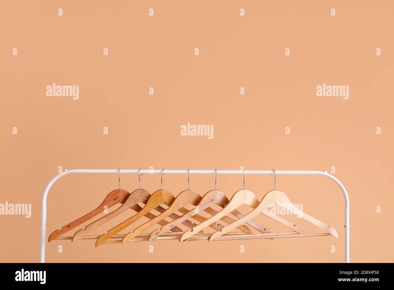 Rack with clothes hangers on color background Stock Photo - Alamy