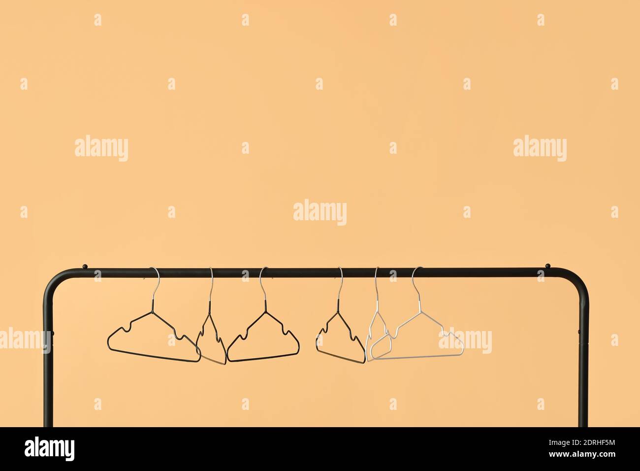 Rack with clothes hangers on color background Stock Photo - Alamy