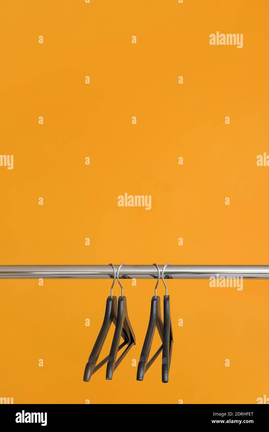 Rack with clothes hangers on color background Stock Photo - Alamy