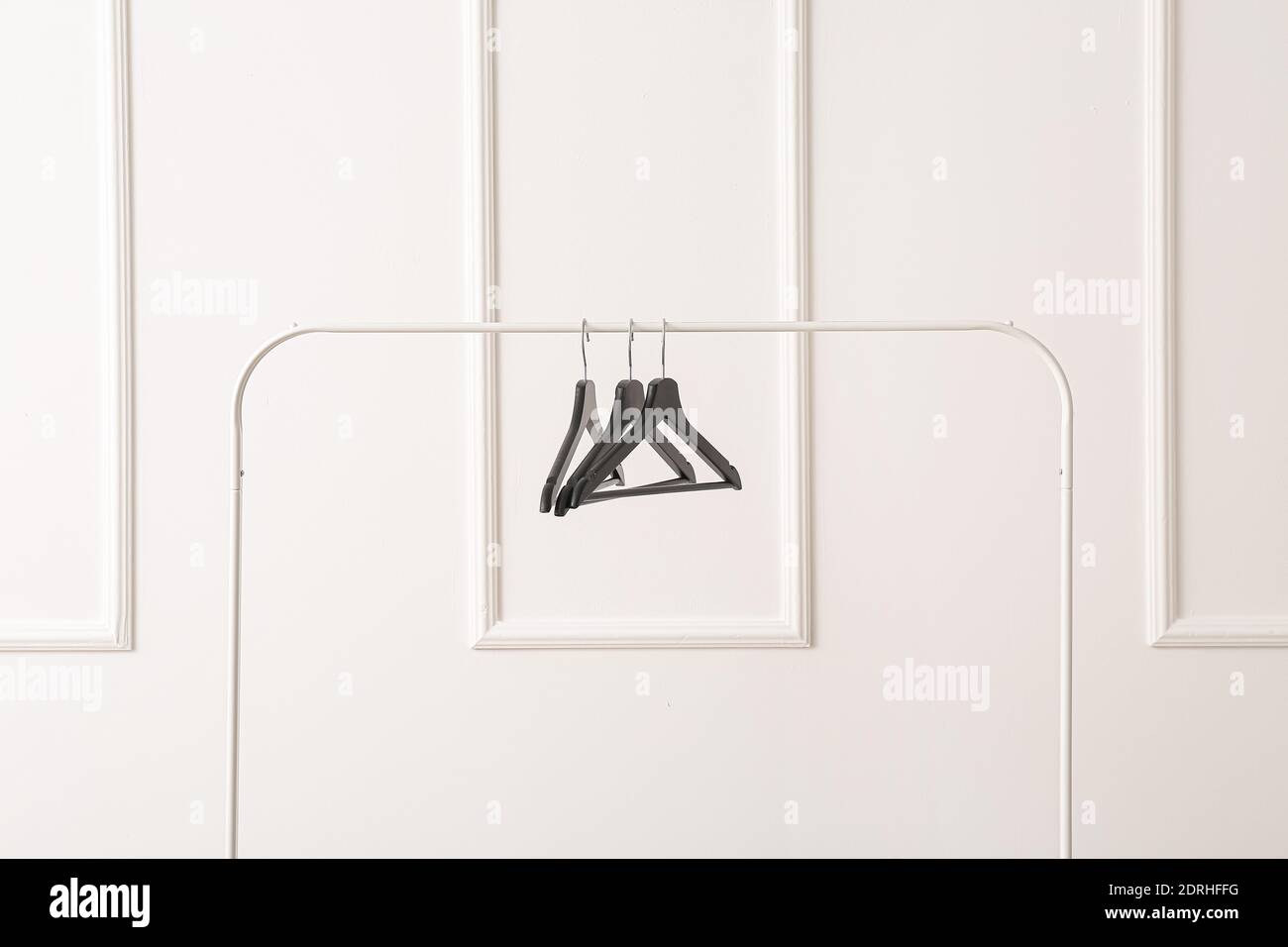 Rack with clothes hangers on white background Stock Photo - Alamy