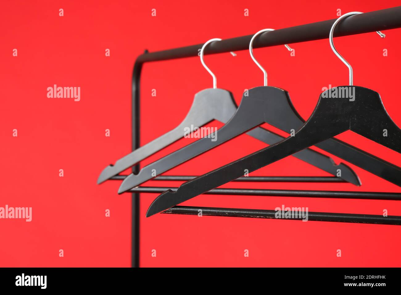 Rack with clothes hangers on color background Stock Photo - Alamy