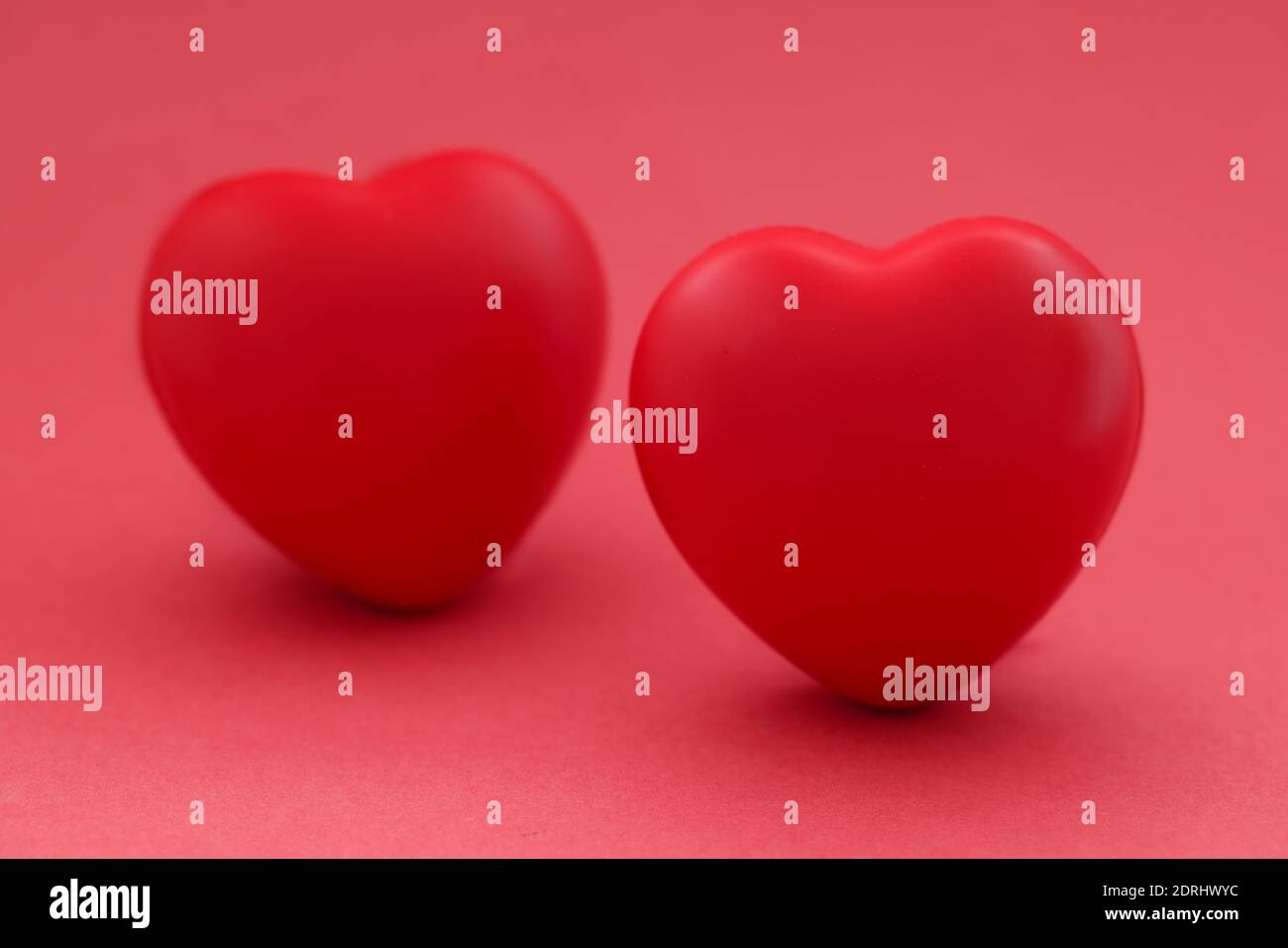 Two red hearts on red background. Relationship between man and woman Stock Photo