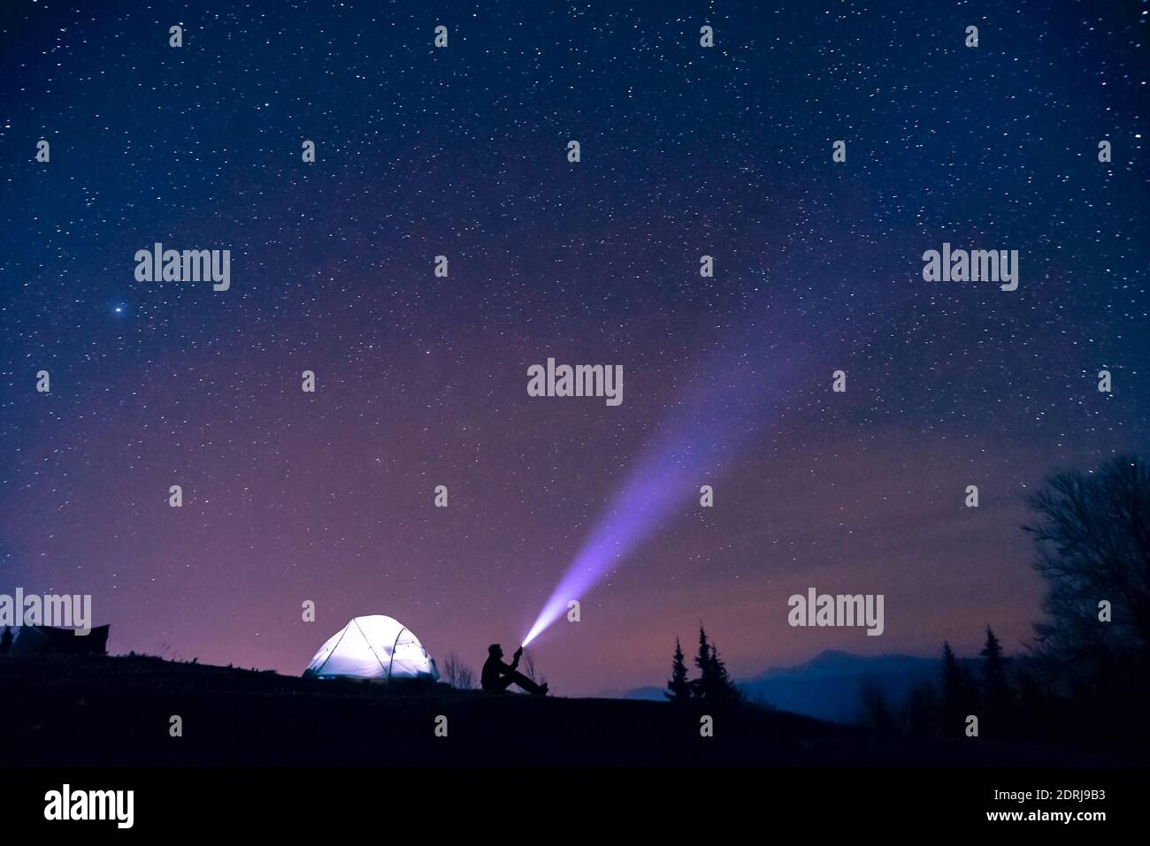 Silhouette Man Flashing Light In Sky At Night Stock Photo Alamy