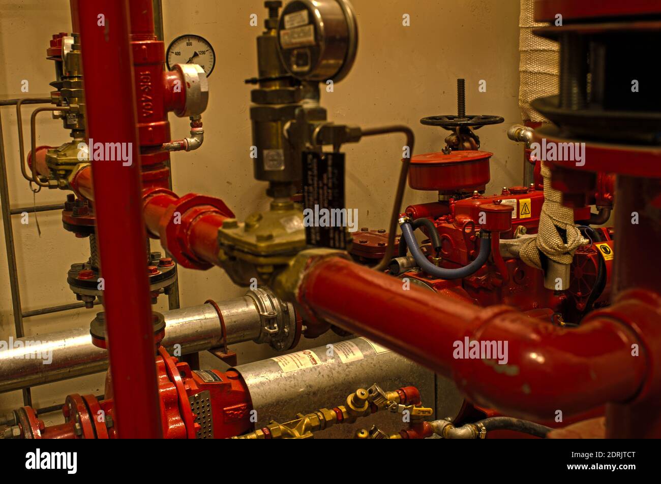 Refurbished fire sprinkler system (c.2010's) located in a decaying top/roof floor plant room of an old, 25+ story city building (c.1970's). Stock Photo