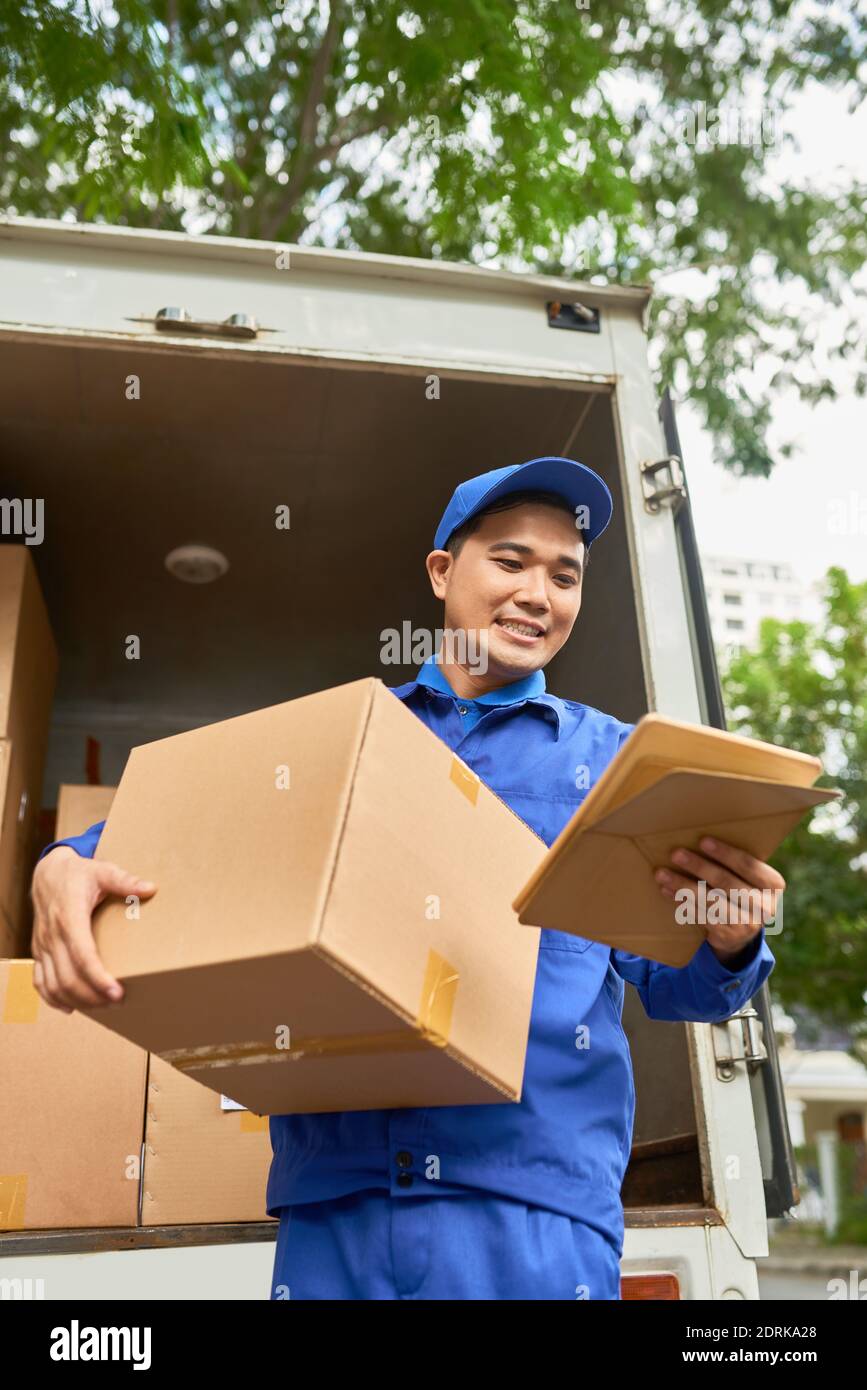 Delivery man carrying big box Stock Photo Alamy