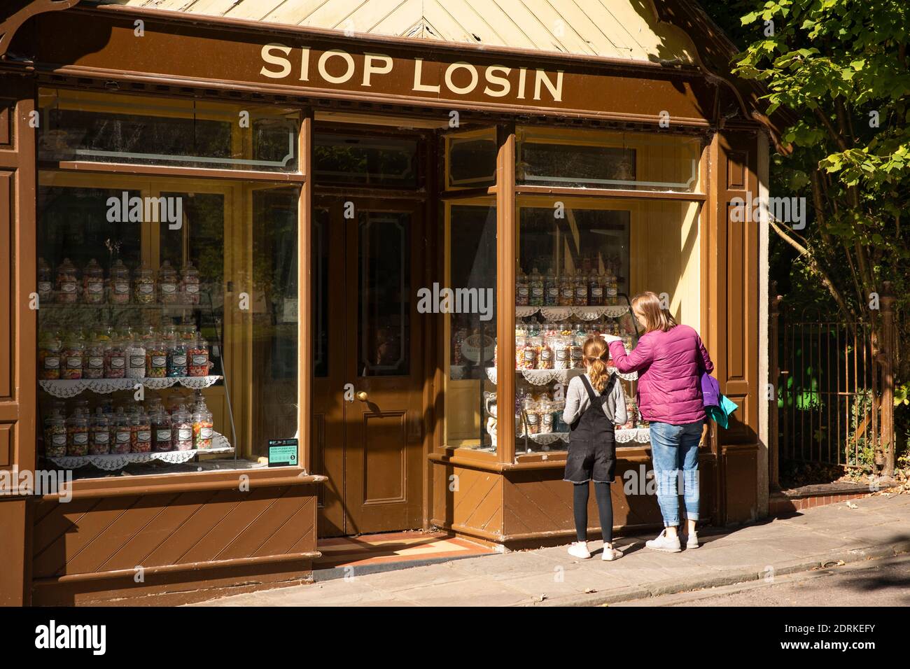 UK, Wales, Cardiff, St Fagans, National Museum of History, mother and child outside Siop Losin, (sweet shop) Stock Photo
