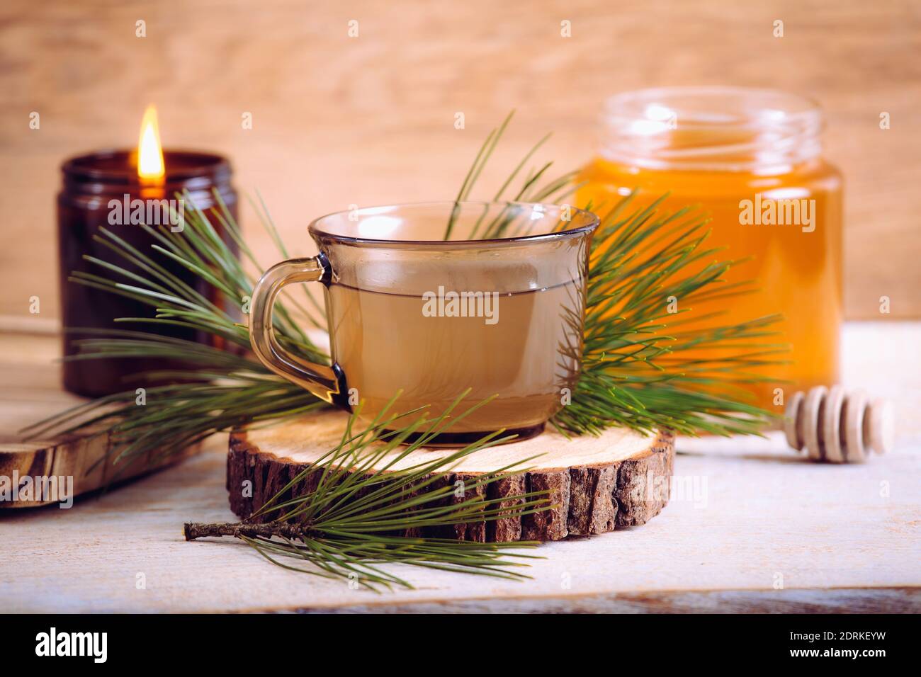 Pine needle tea infusion with honey. Tree branches for decoration. Indoors home, healthy full of vitamin C. Cozy set. Stock Photo