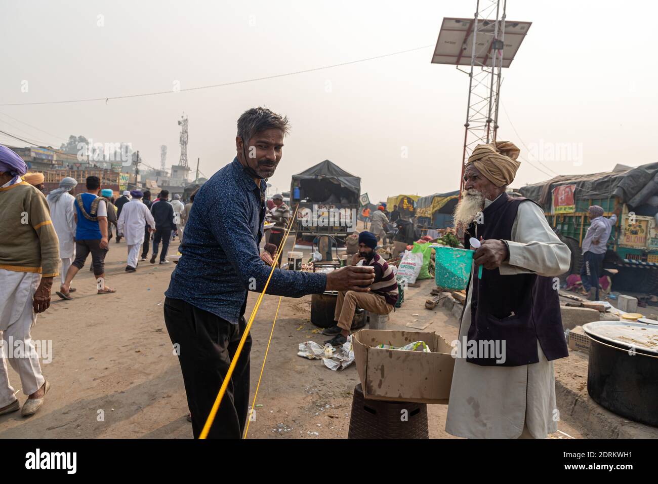 an aged farmer serving food during the protest at delhi border. Stock Photo