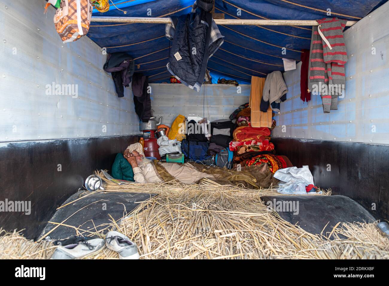 an aged farmer taking rest during the protest in their trolley at delhi border. Stock Photo