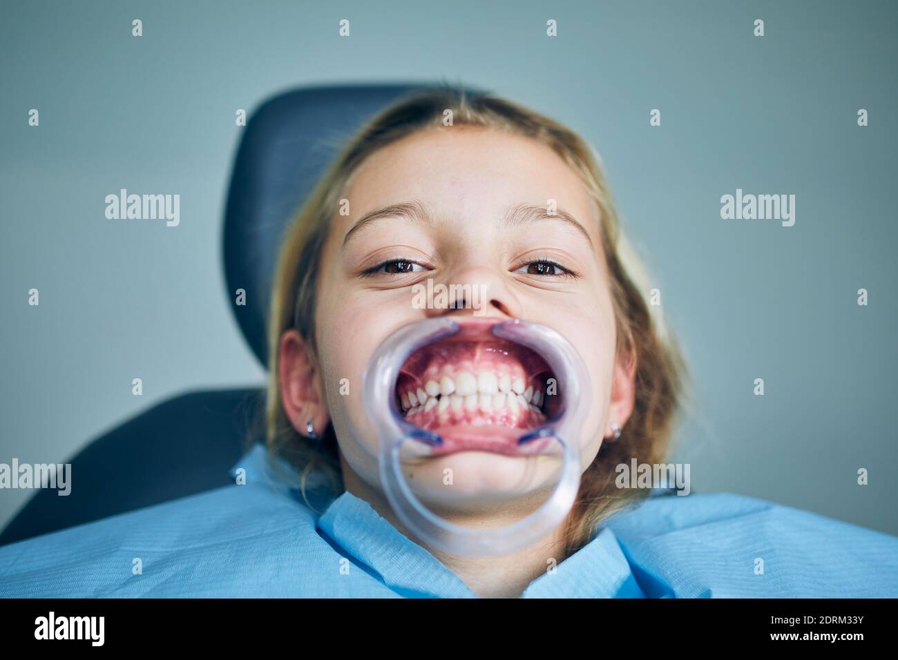 Portrait of young patient in dentist office. Girl during dental examination. Stock Photo
