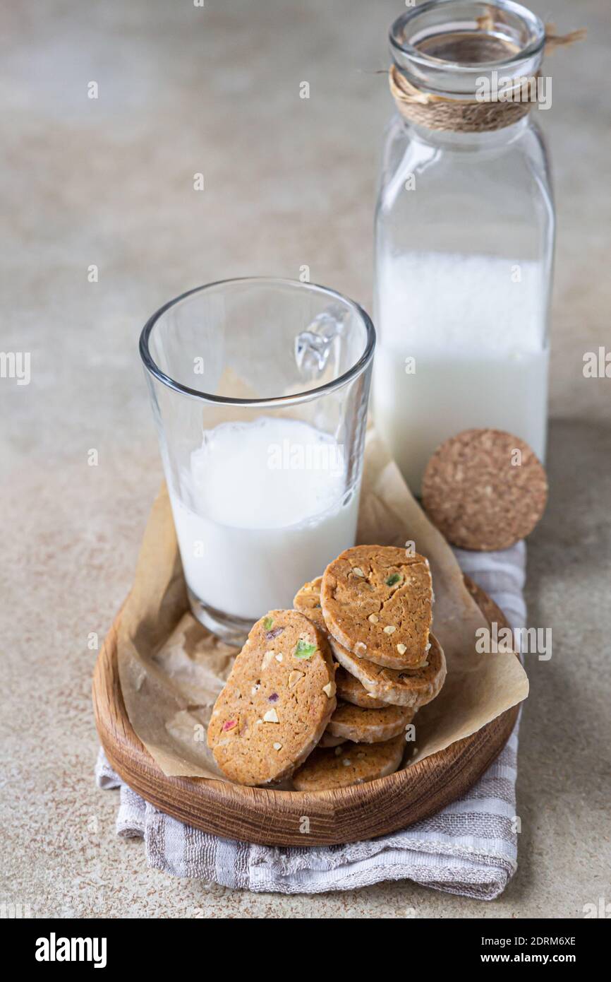 Danish spicy butter cookies with candied fruits, cinnamon sticks and anise and glass of milk, light concrete background. Selective focus. Stock Photo