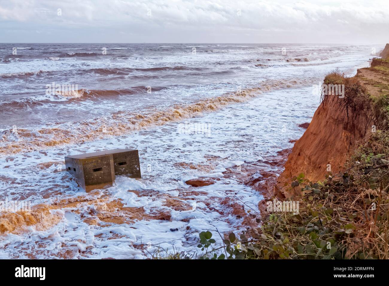WW2 Pill box washed in the sea due to coastal erosion on the Suffolk coast, England Stock Photo