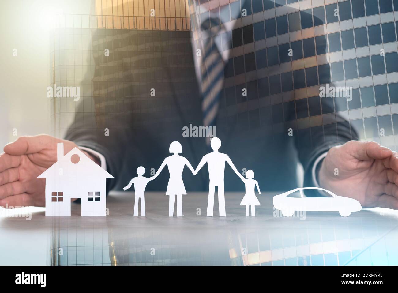 Insurer protecting house, family and car with his hands; multiple exposure Stock Photo