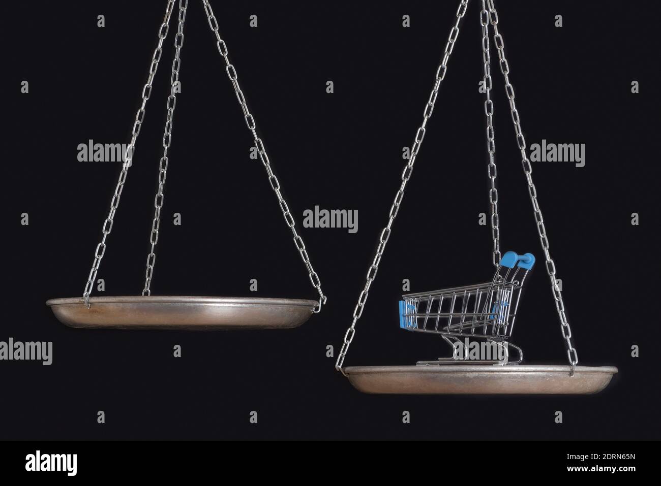 Balance scales and grocery cart on black background close up Stock Photo Alamy
