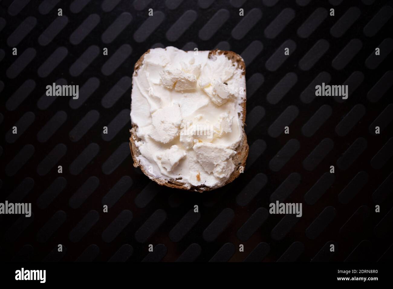 Rustic piece of bread with only sour cream on it. Poverty and hunger concept Stock Photo