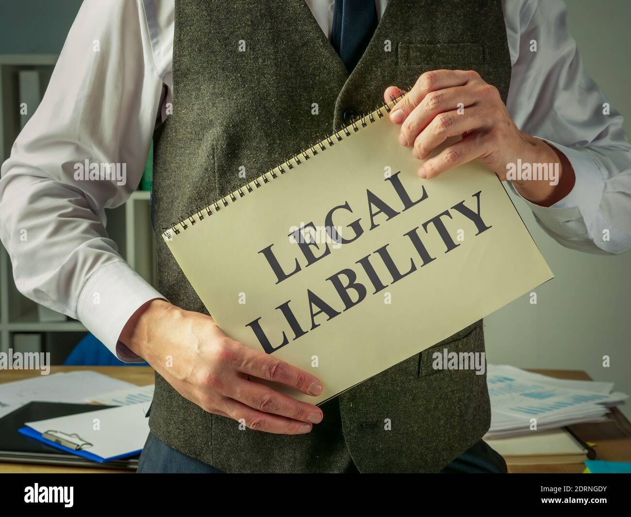 The clerk holds a book about legal liability. Stock Photo