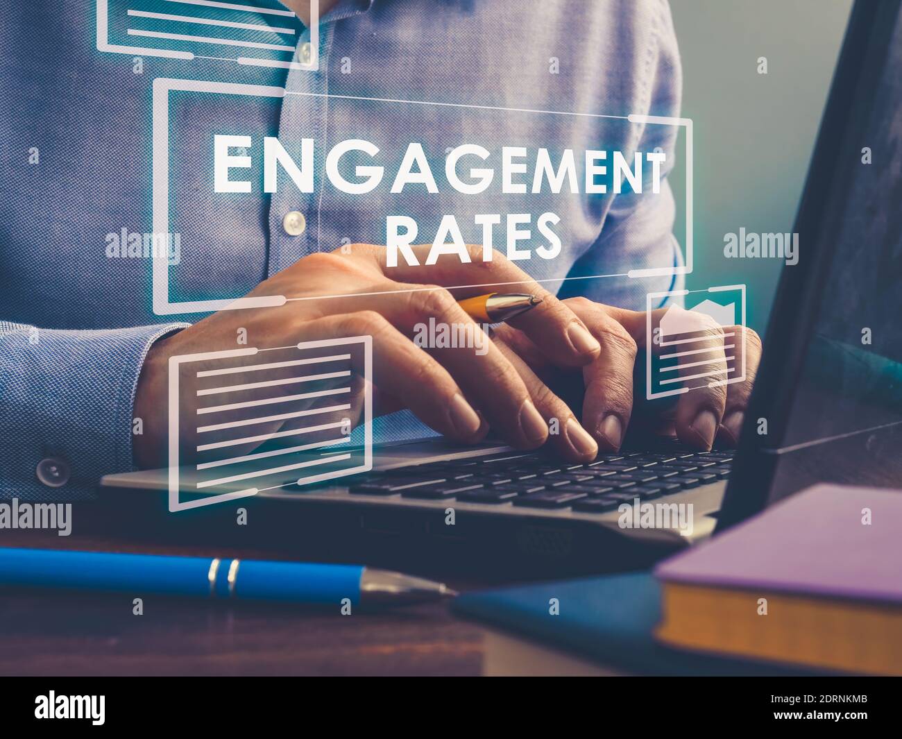 Engagement Rates sign on screen. A man works on a laptop. Stock Photo