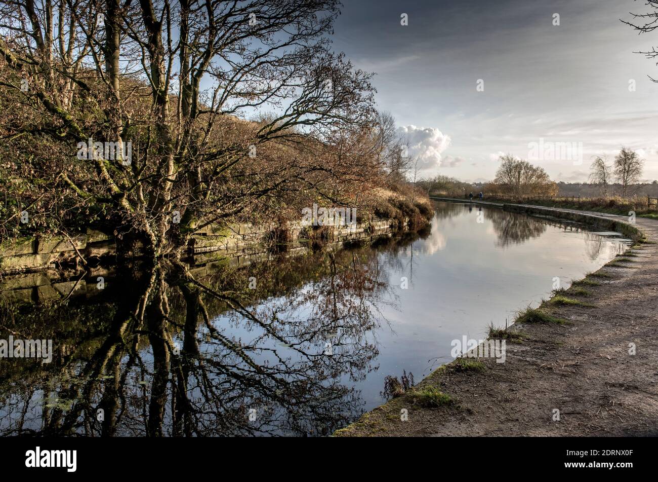 Manchester, Bolton and Bury Canal in Little Lever, Bolton. Walkers take advantage of a glorious winter day to take in the scenery along the disused ca Stock Photo