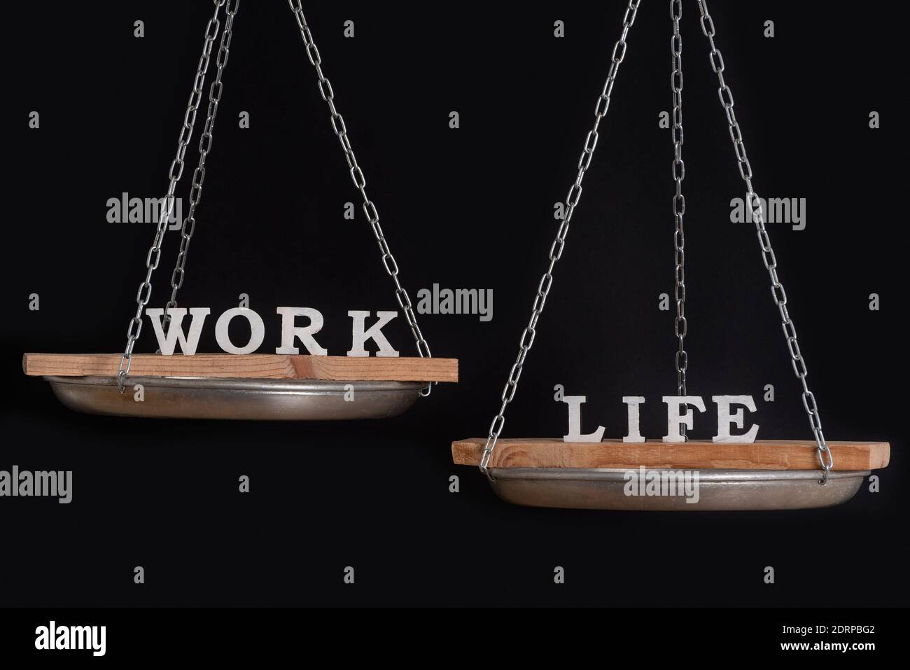 Balance work and personal life. Scales on black background close up ...