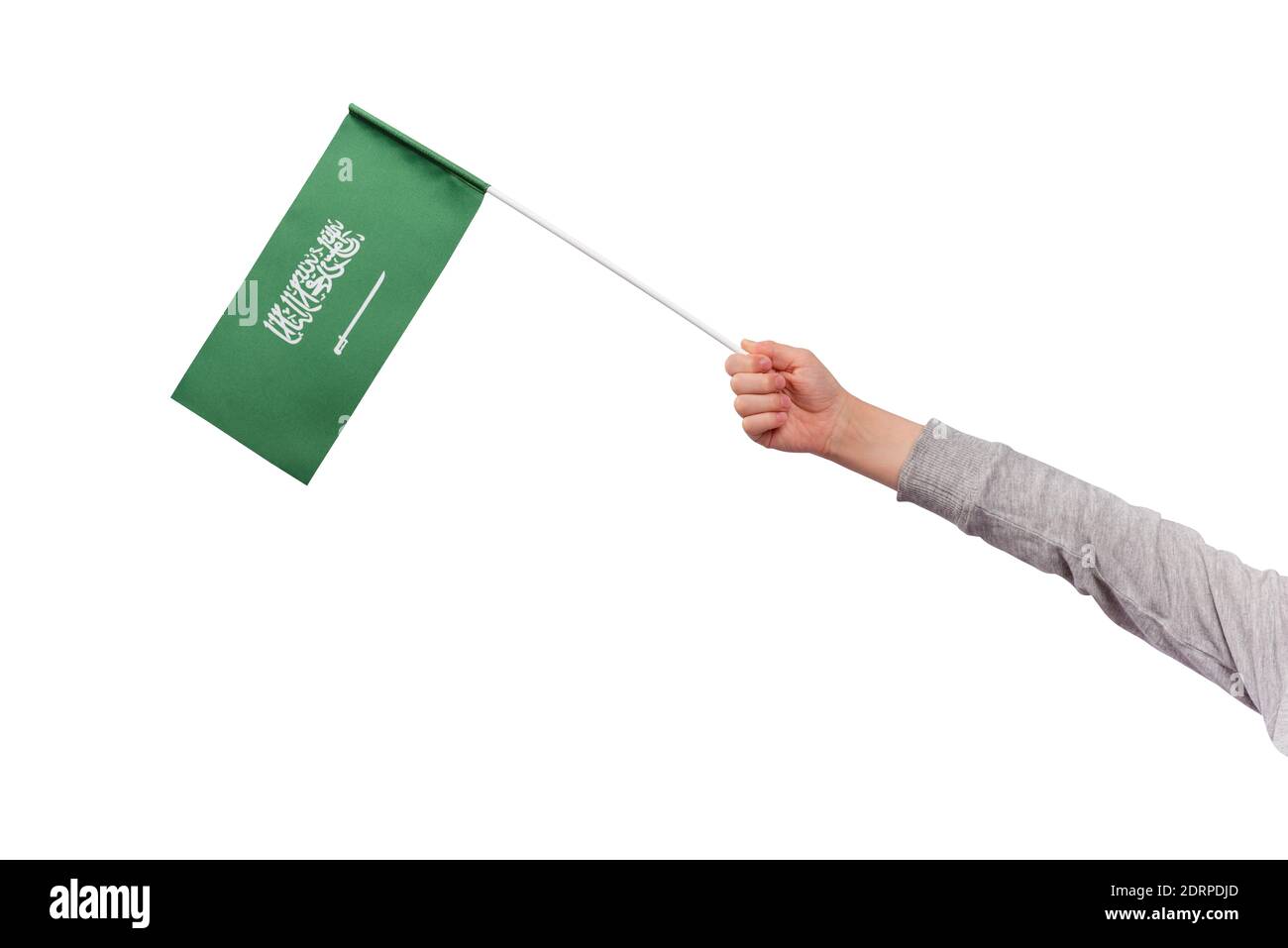 Child holds flag of Saudi Arabia isolated on white background. Green flag with sword. Stock Photo