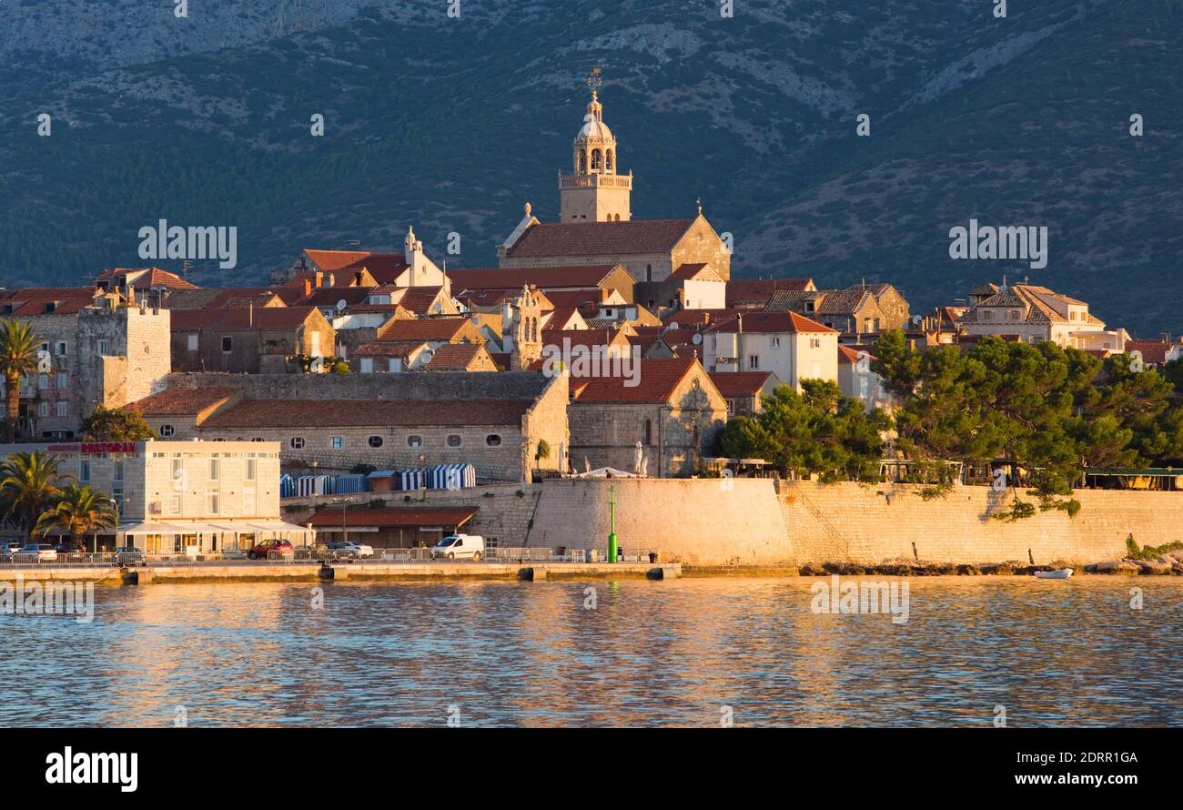 Korčula Town, Korčula, Dubrovnik-Neretva, Croatia. View across bay to the Old Town, sunrise, St Mark's Cathedral prominent. Stock Photo