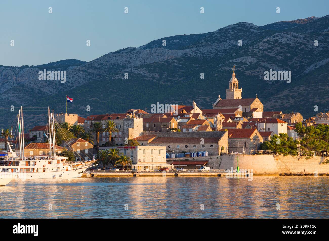 Korčula Town, Korčula, Dubrovnik-Neretva, Croatia. View across bay to the Old Town, sunrise, St Mark's Cathedral prominent. Stock Photo