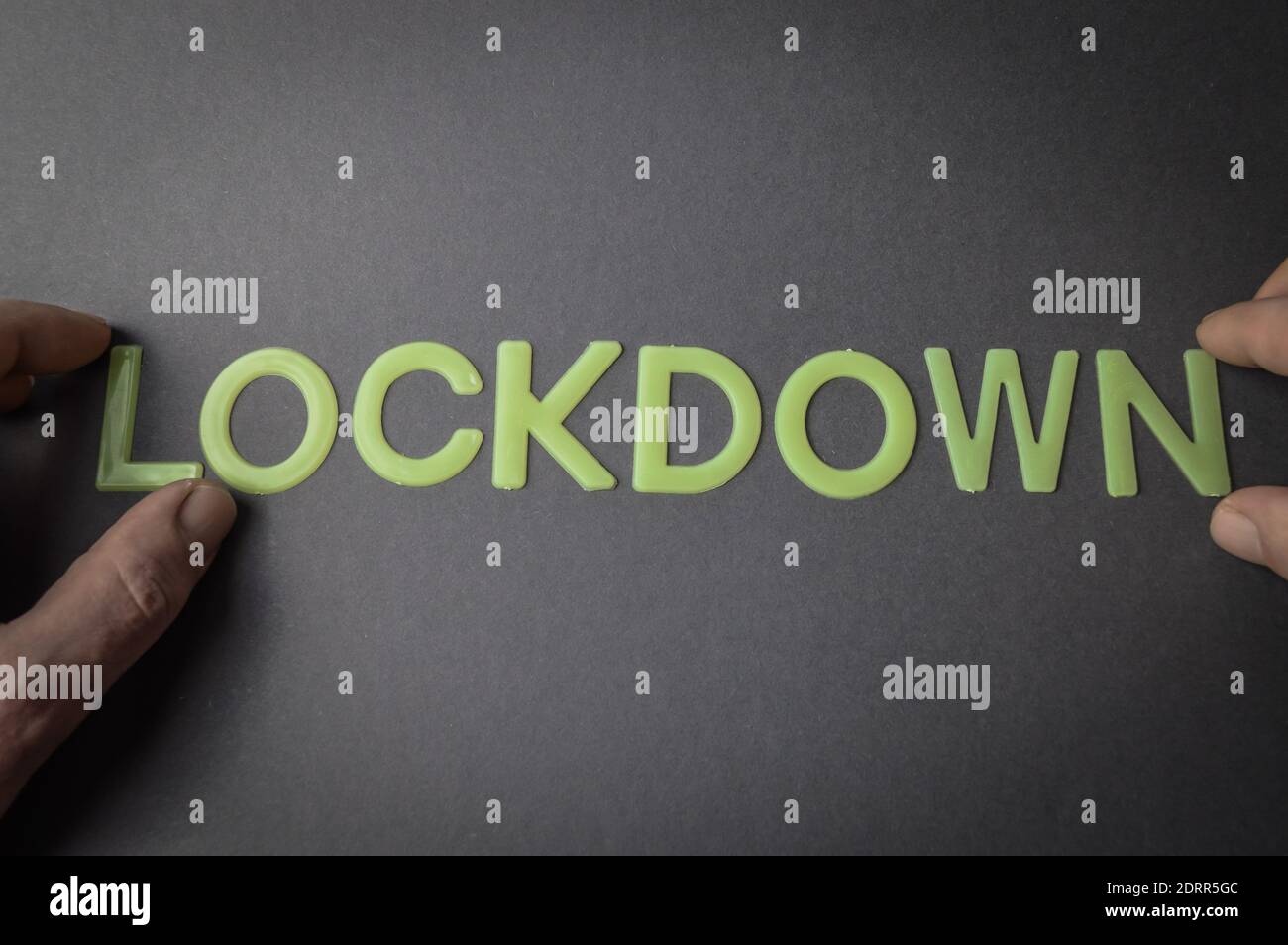 Lockdown In Sign Language Human fingers holding the word Lockdown written with plastic letters on ...