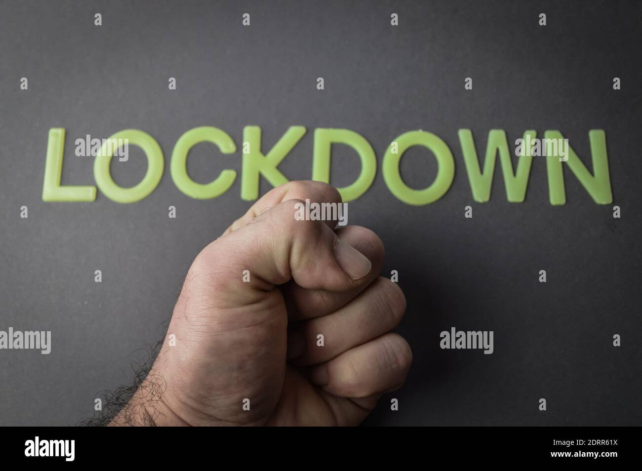 Lockdown In Sign Language Human fist against the word Lockdown written with plastic letters on ...