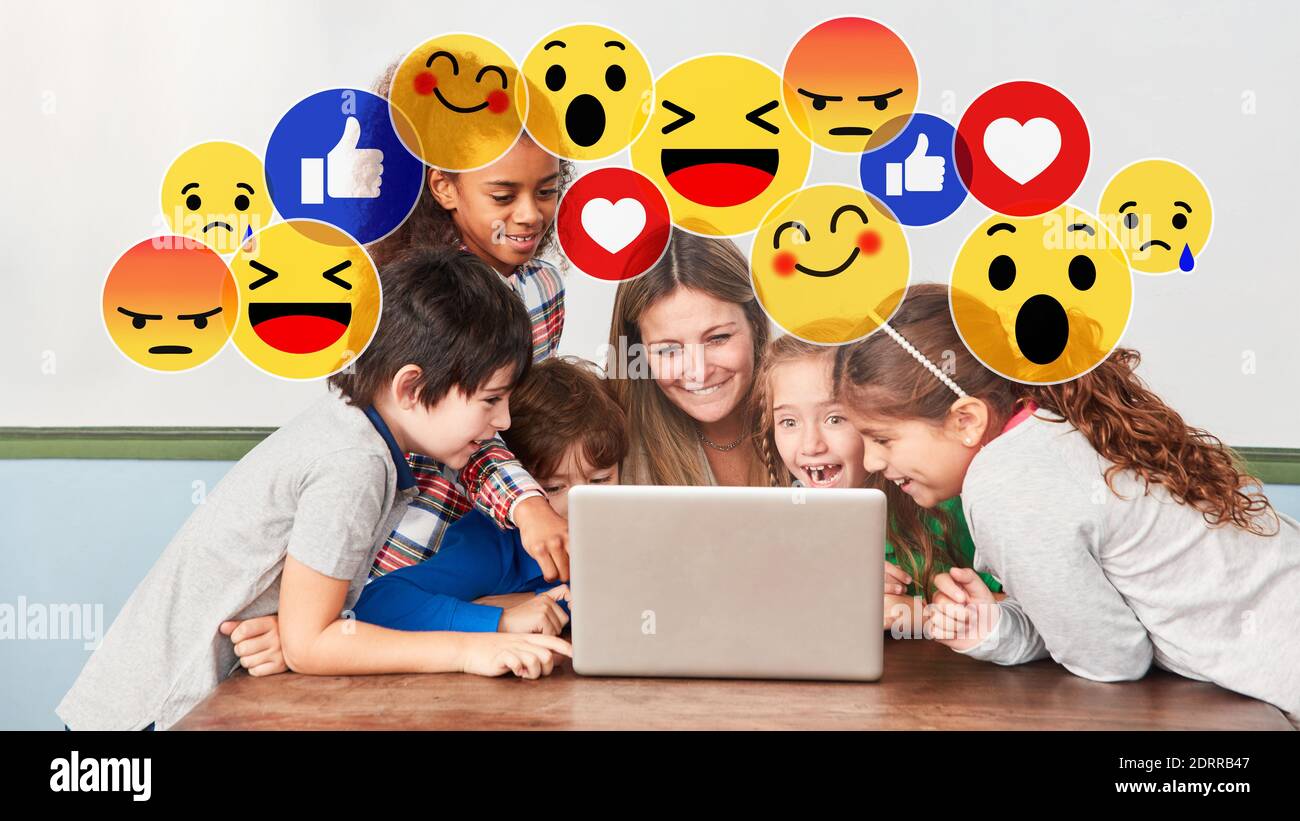 Children and teacher have fun together with social media in computer class Stock Photo
