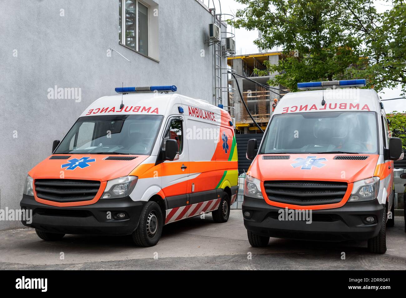 Two modern white and orange ambulance medical emergency vans truck