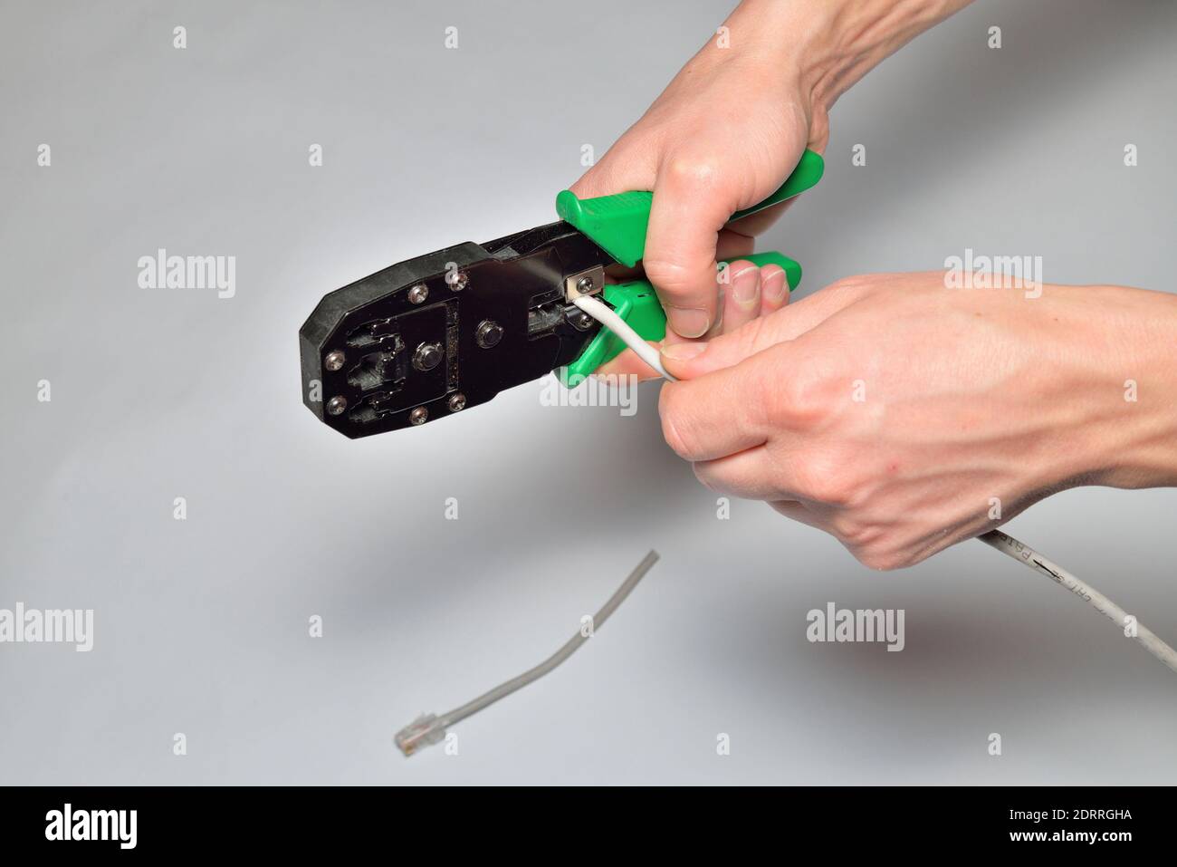 Hands of an electrician cut off the computer twisted pair tongs Stock Photo