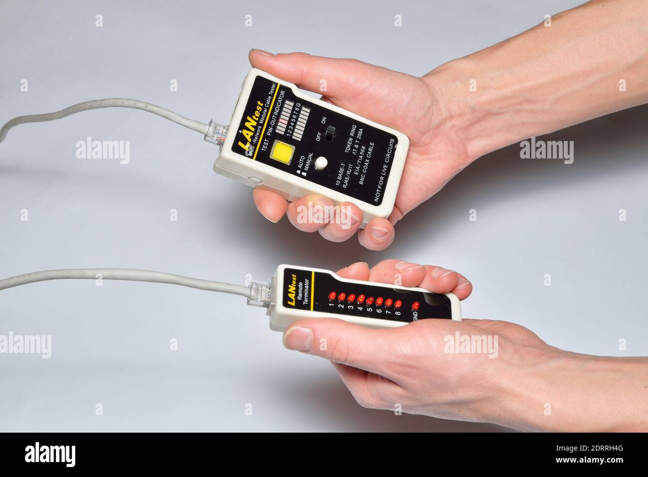 Hands of the installer Ethernet LAN check tester for twisted pair Stock Photo