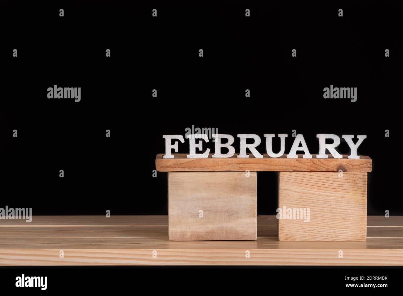 Word February from wooden letters. Wooden calendar. Black background ...