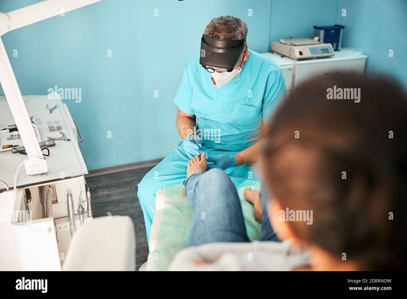 Professional chiropodist treating feet during medical procedure Stock Photo