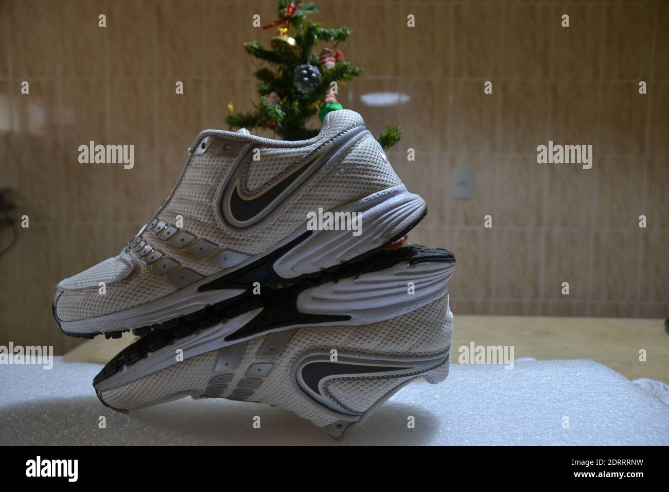 Women's running shoes on white background with Christmas tree in the background Stock Photo