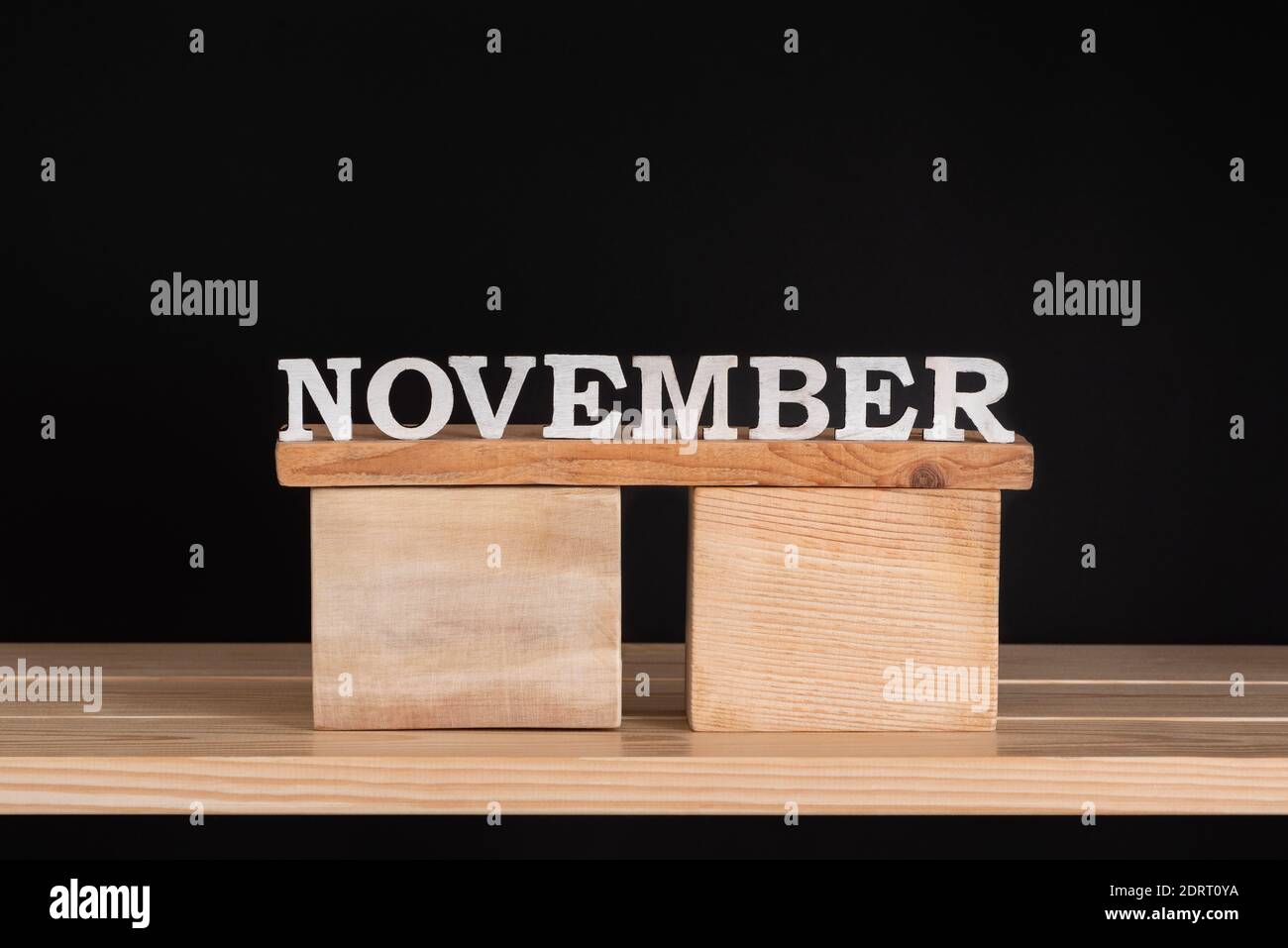 Word November by wooden letters on black background. Front view. Autumn ...