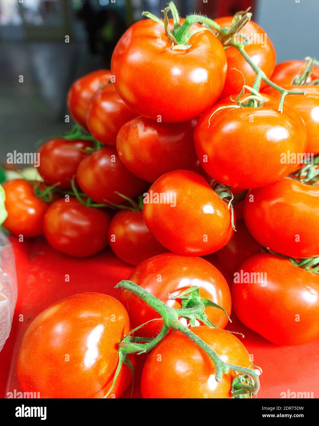 red ripe tomatoes with a branch lie on the market Stock Photo - Alamy