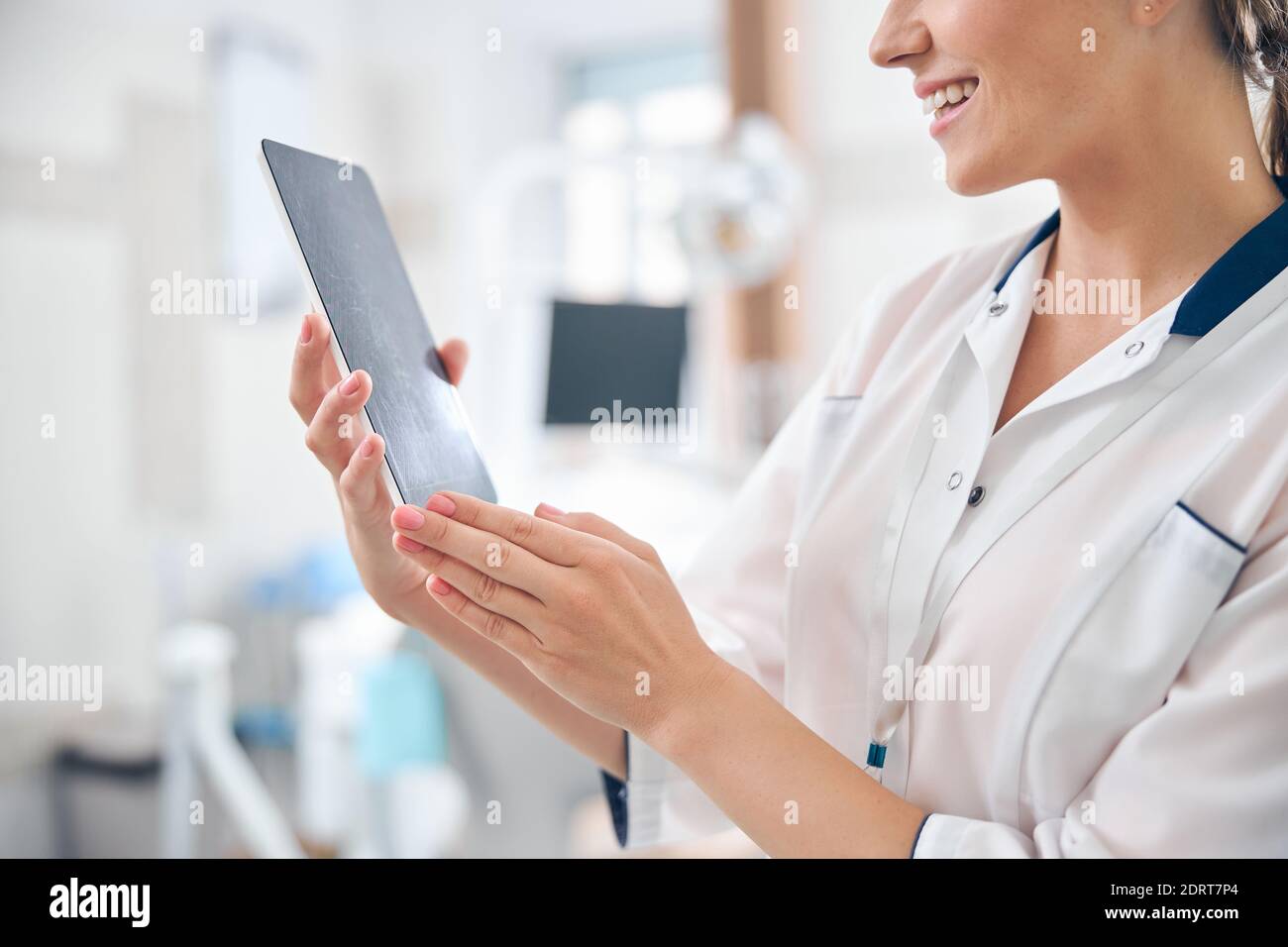 Smiling female dentist using touchpad at work Stock Photo