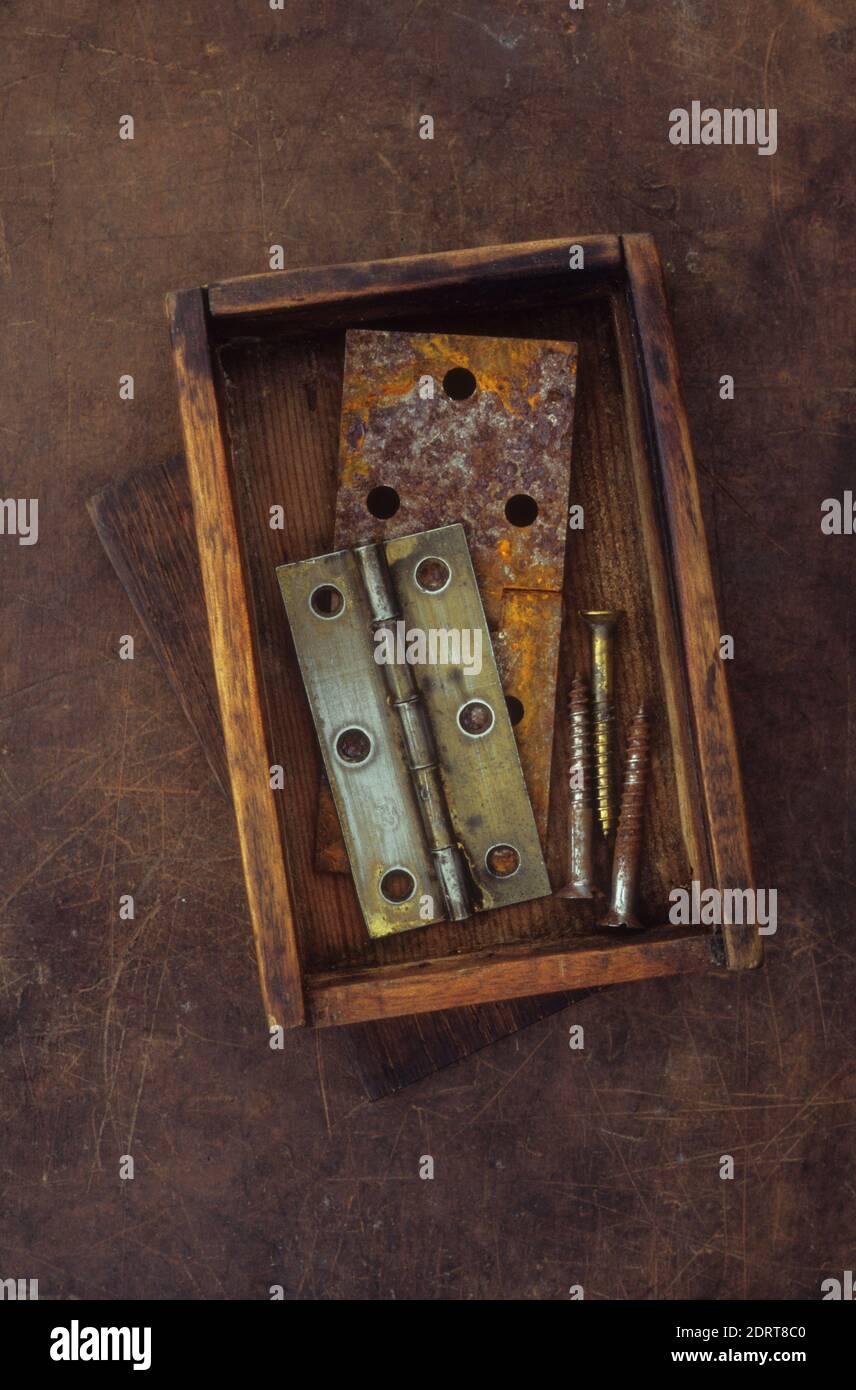Small old wooden box containing tarnished brass door hinge and used brass screws Stock Photo Alamy